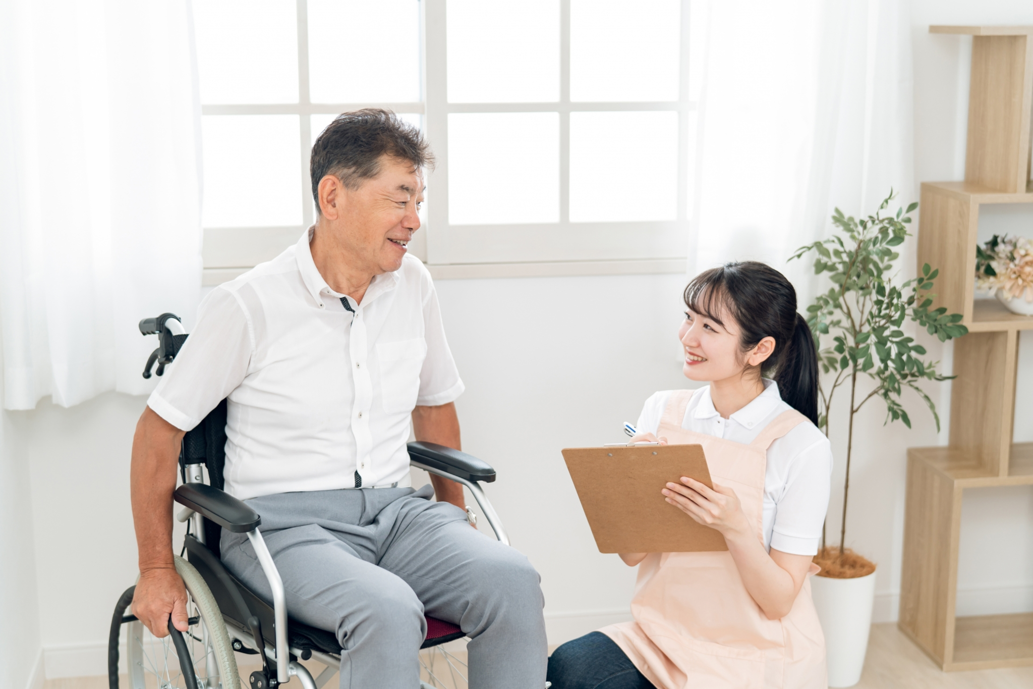 高齢者女性と話す介護士(メモ)