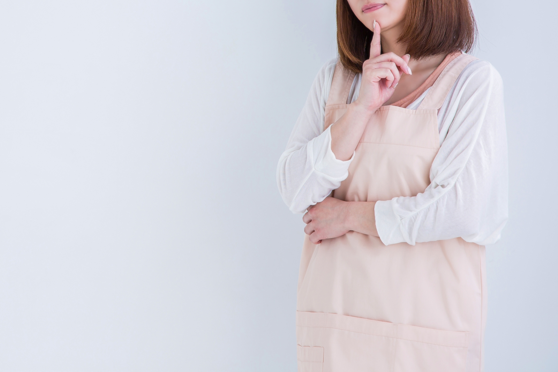 アイディアを思い浮かべるエプロン姿の女性