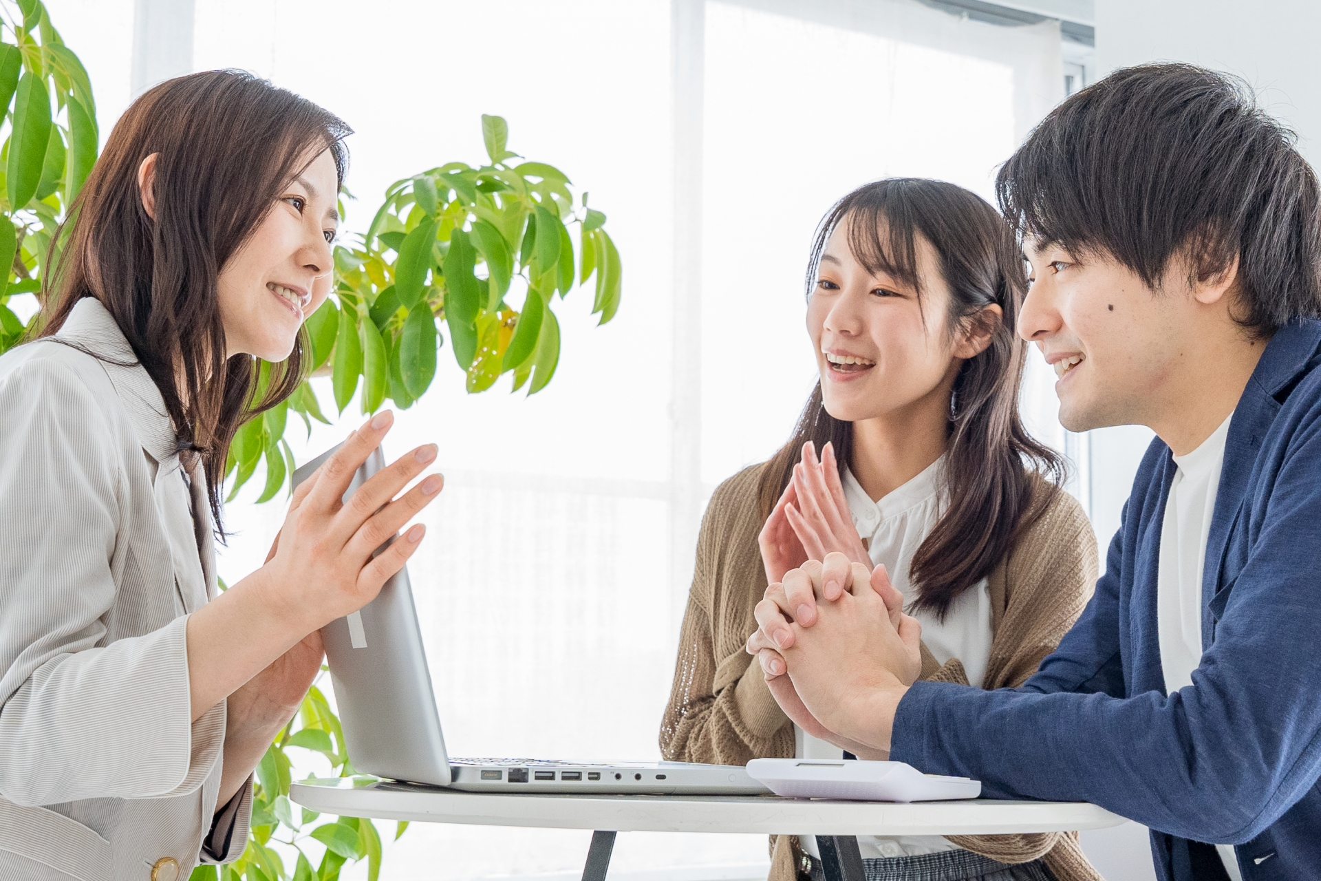 女性の説明に喜ぶ若い夫婦