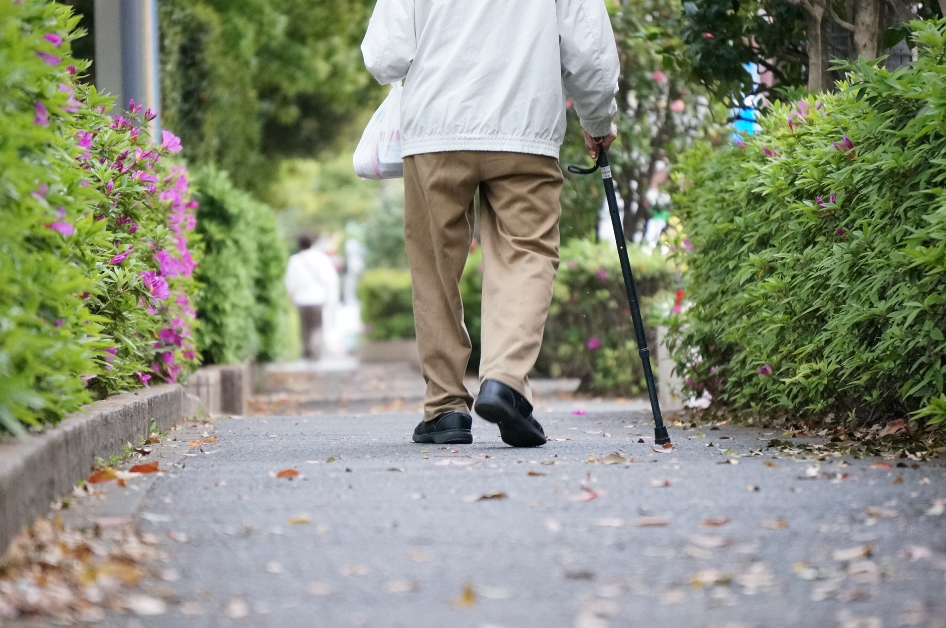 杖をついて歩くお年寄り