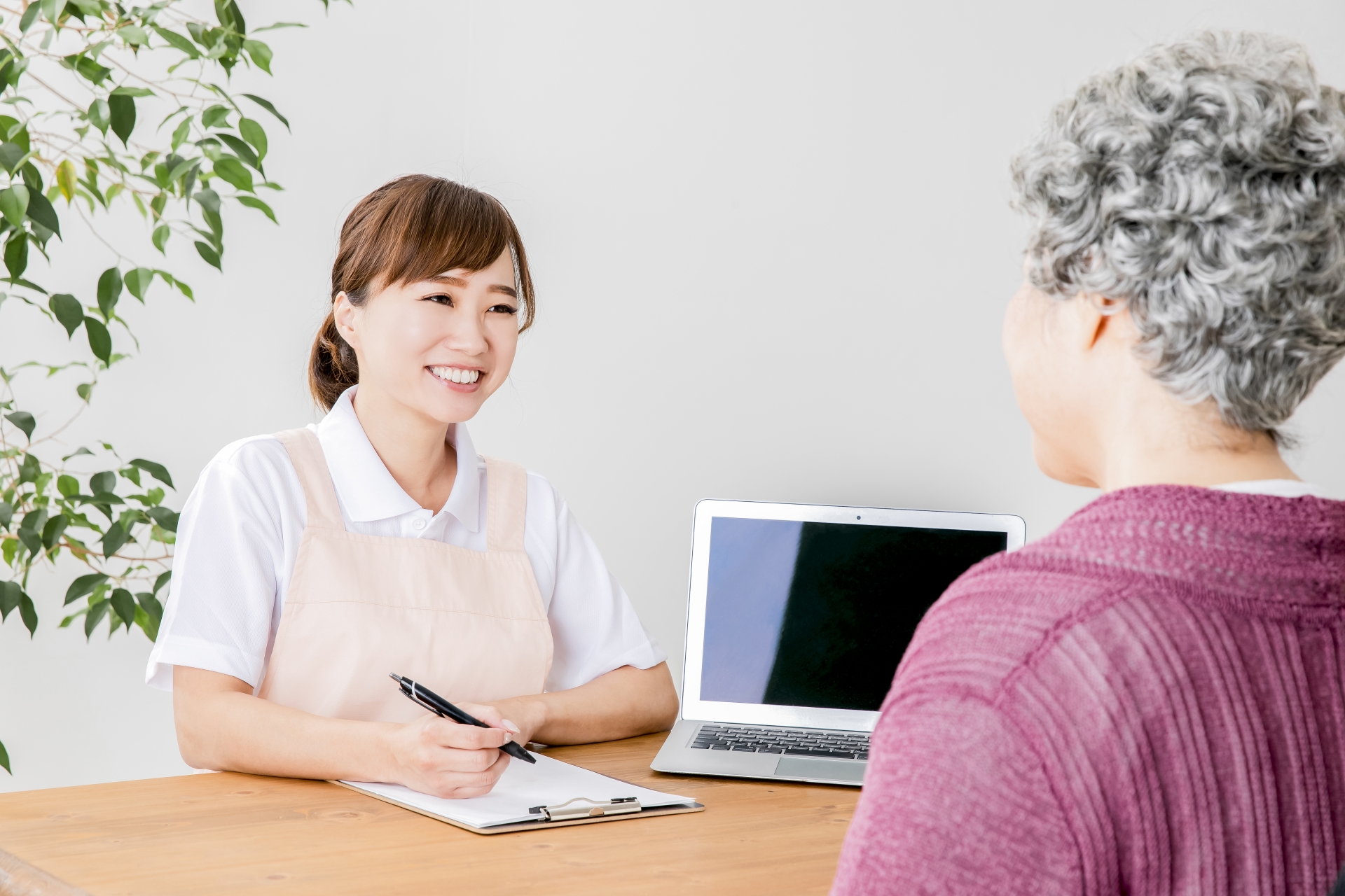 説明する介護士と高齢者の女性
