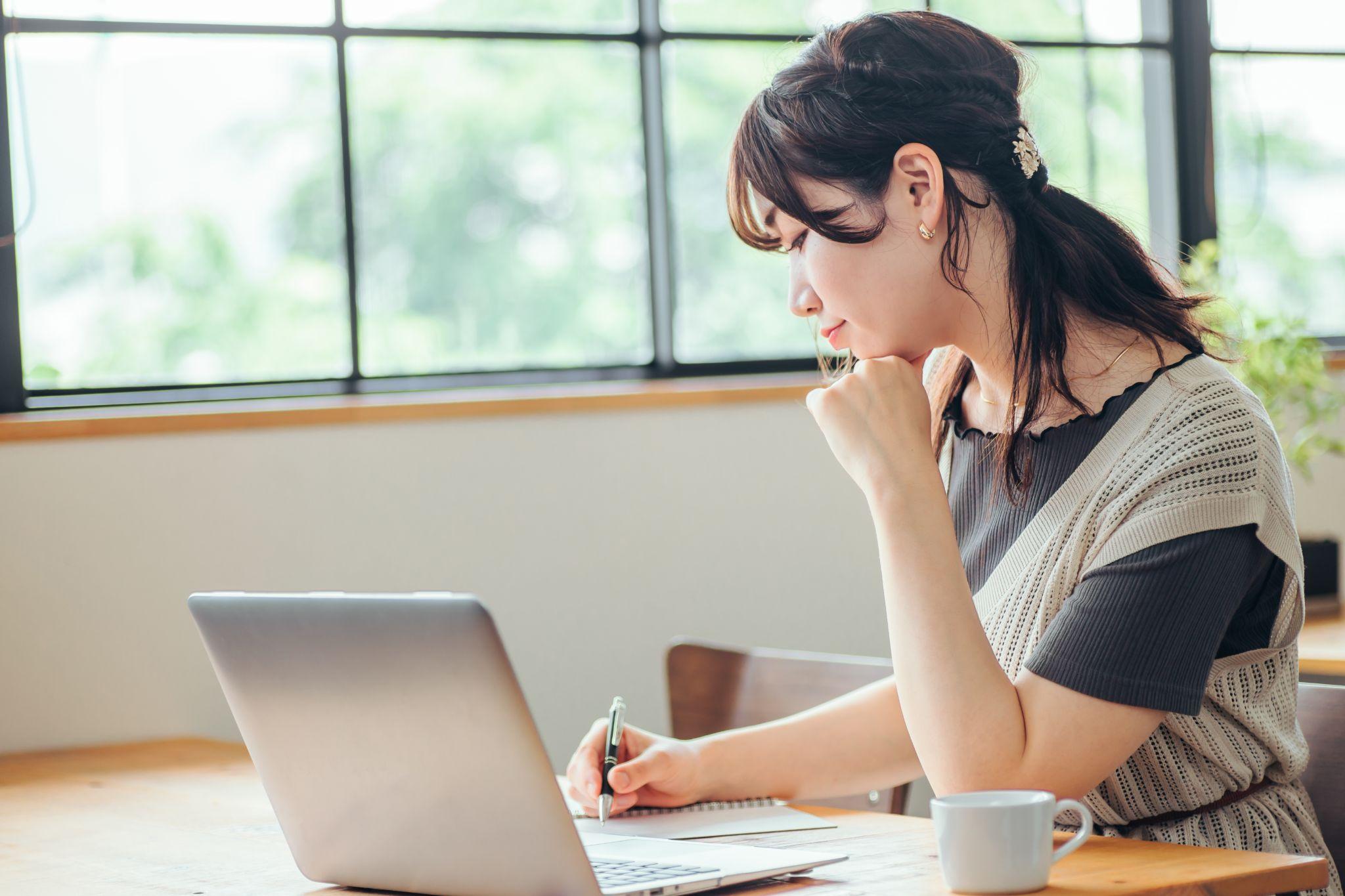 おしゃれ空間で勉強する女性(笑顔)