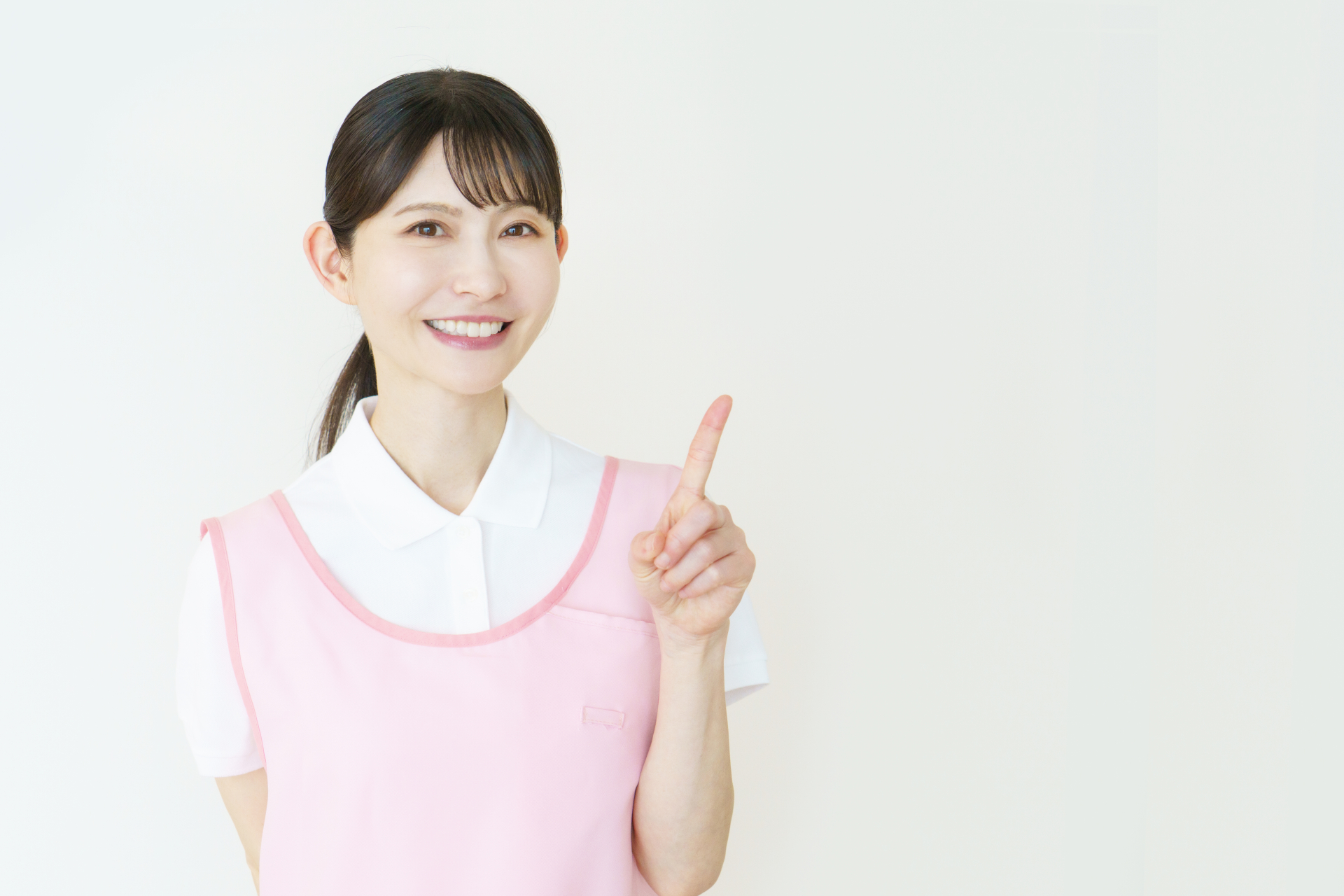1番のポーズをする若い日本人女性介護士