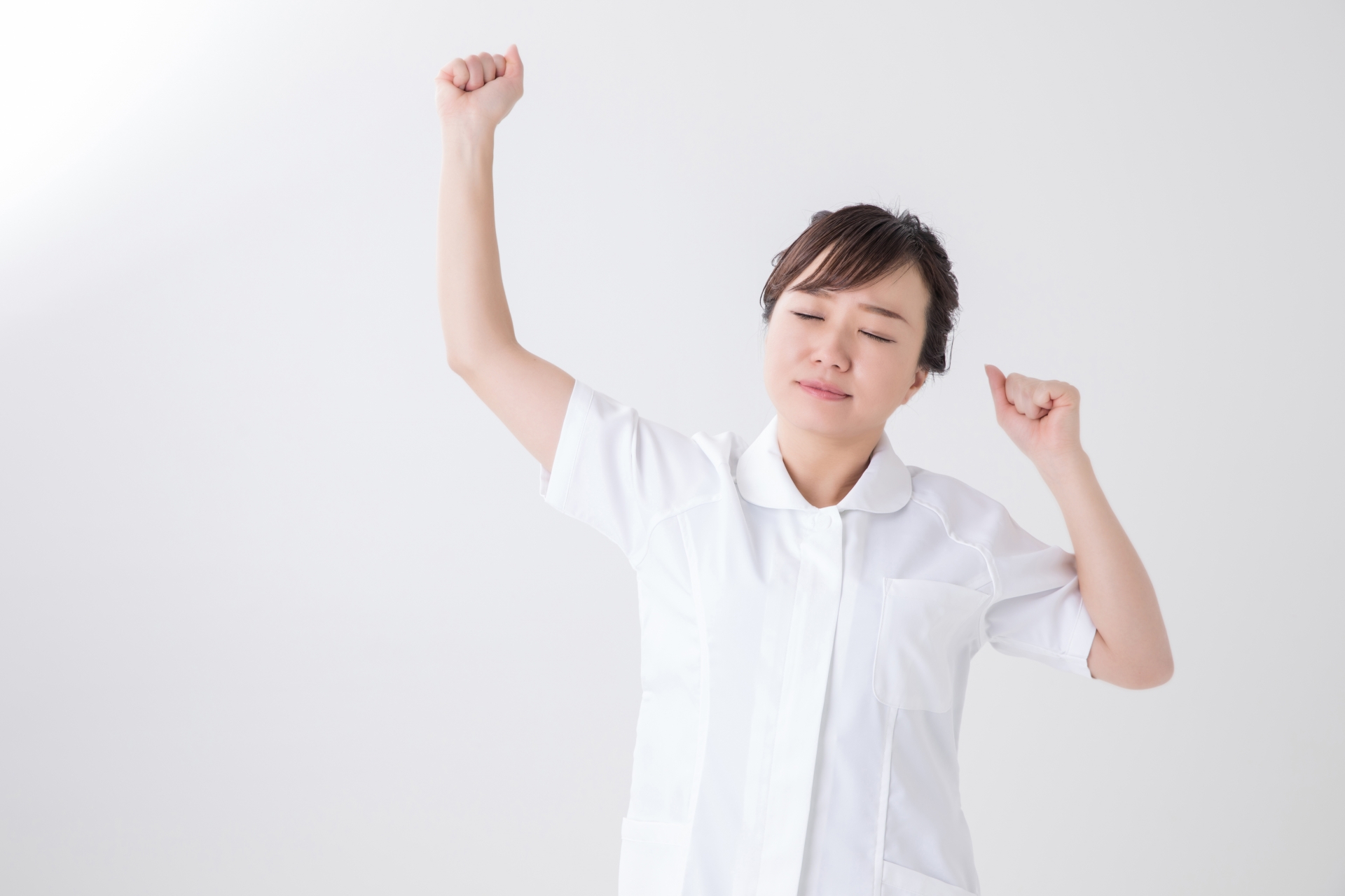 伸びをする白衣の女性