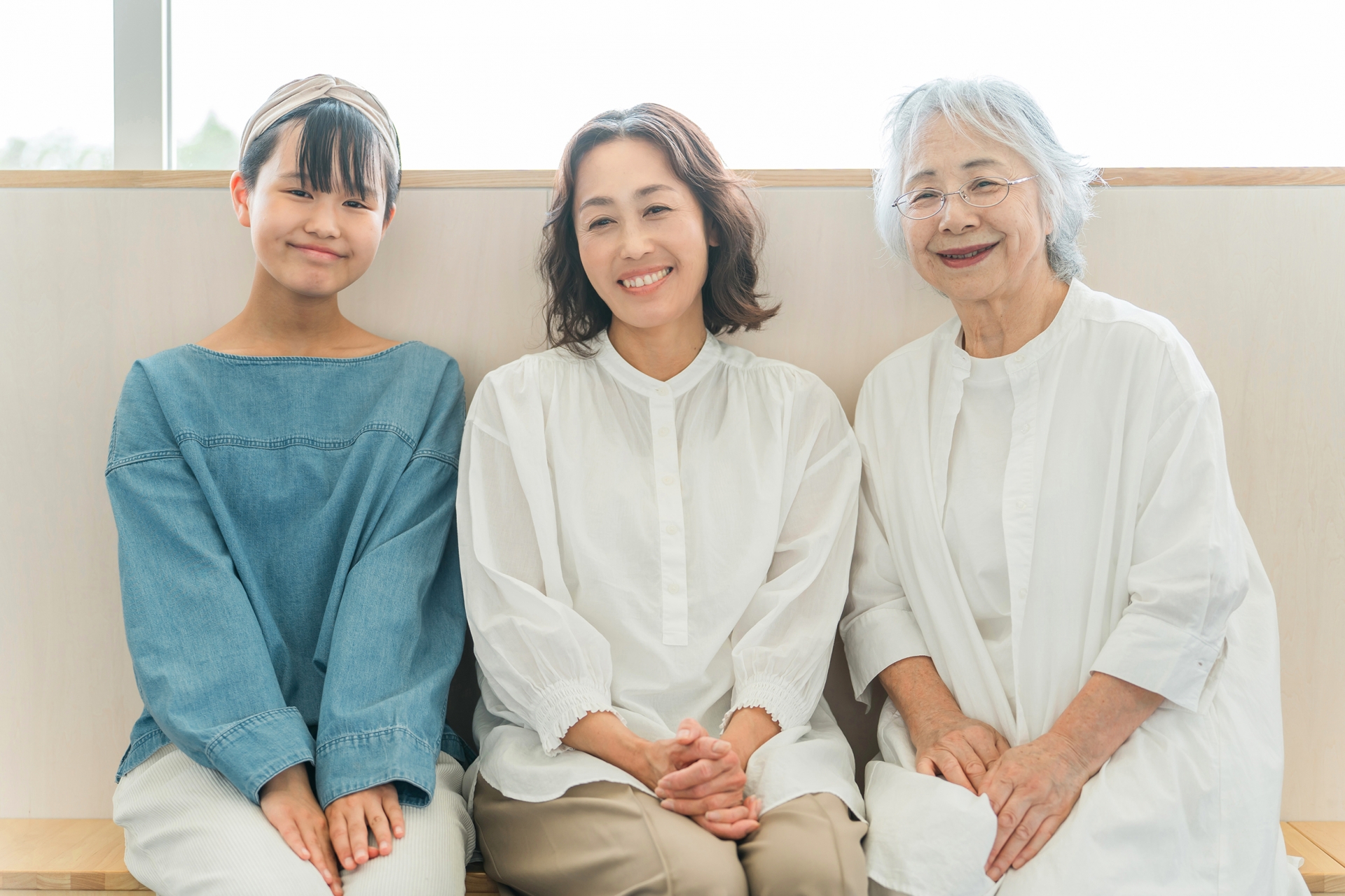 座って話をする三世代親子(孫・母・祖母)