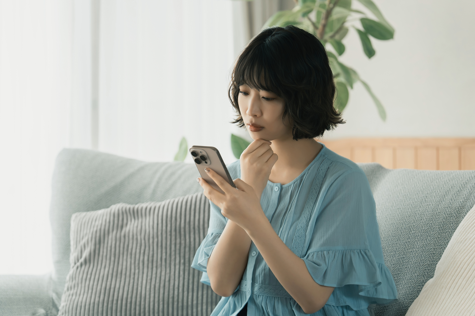 スマホを使いながら考えごとをする女性