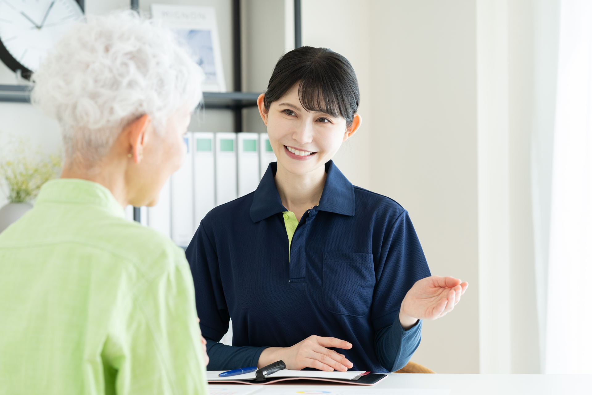シニアの女性に説明する介護福祉士