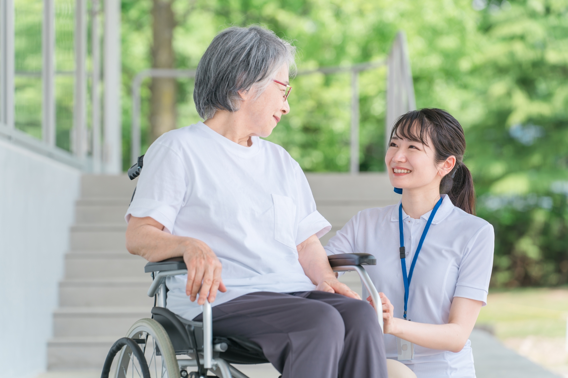 車椅子に乗った高齢者と介護士（ヘルパー）