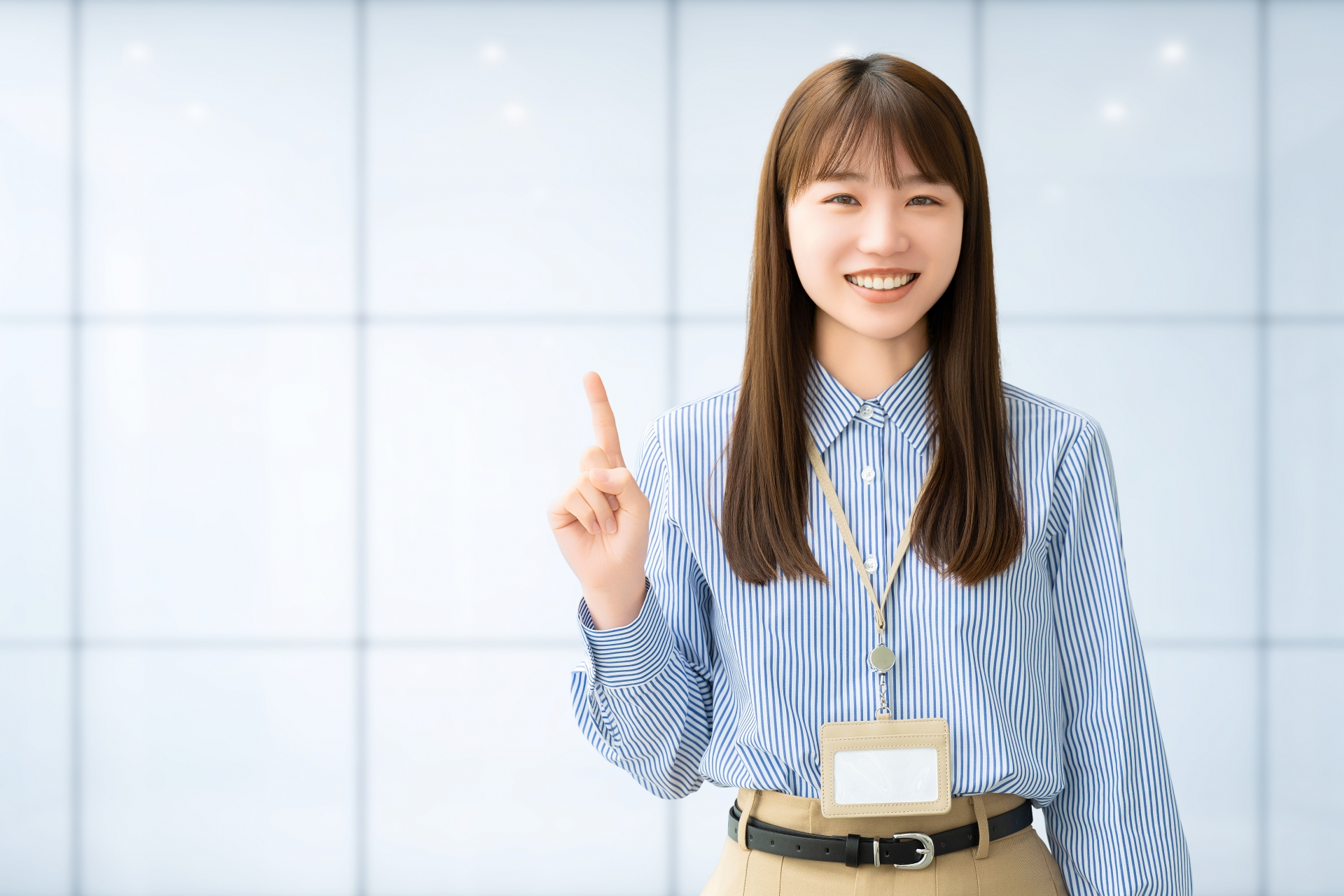人差し指を立てて案内する若い女性