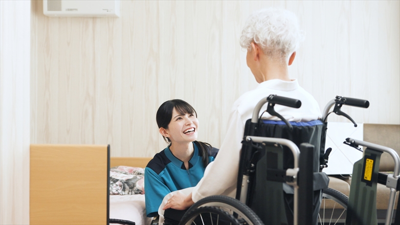 高齢者の移乗介助をするアジア人介護士