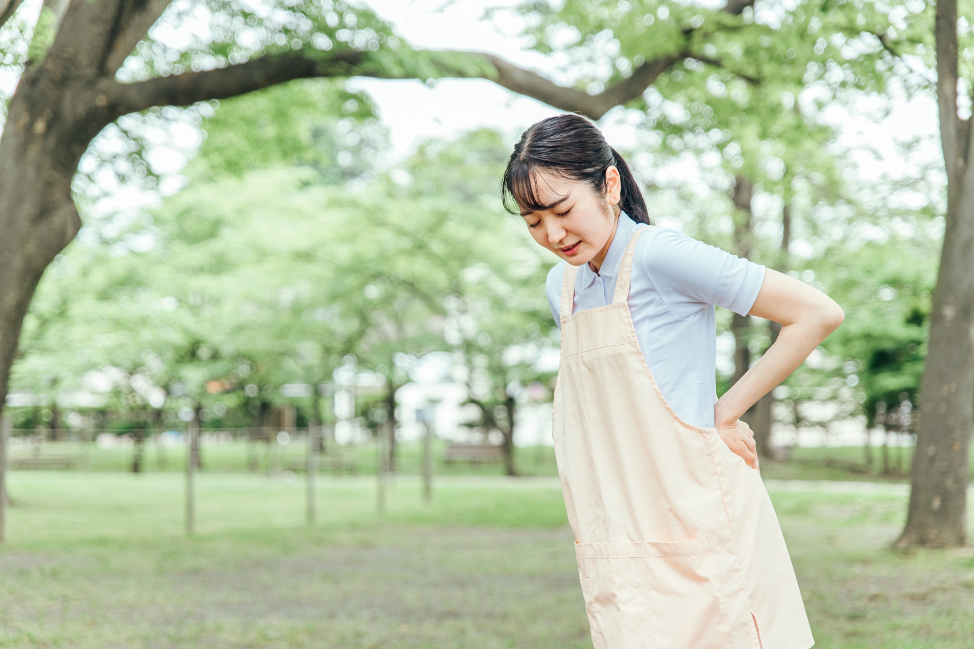 エプロンをつけた女性（腰痛）