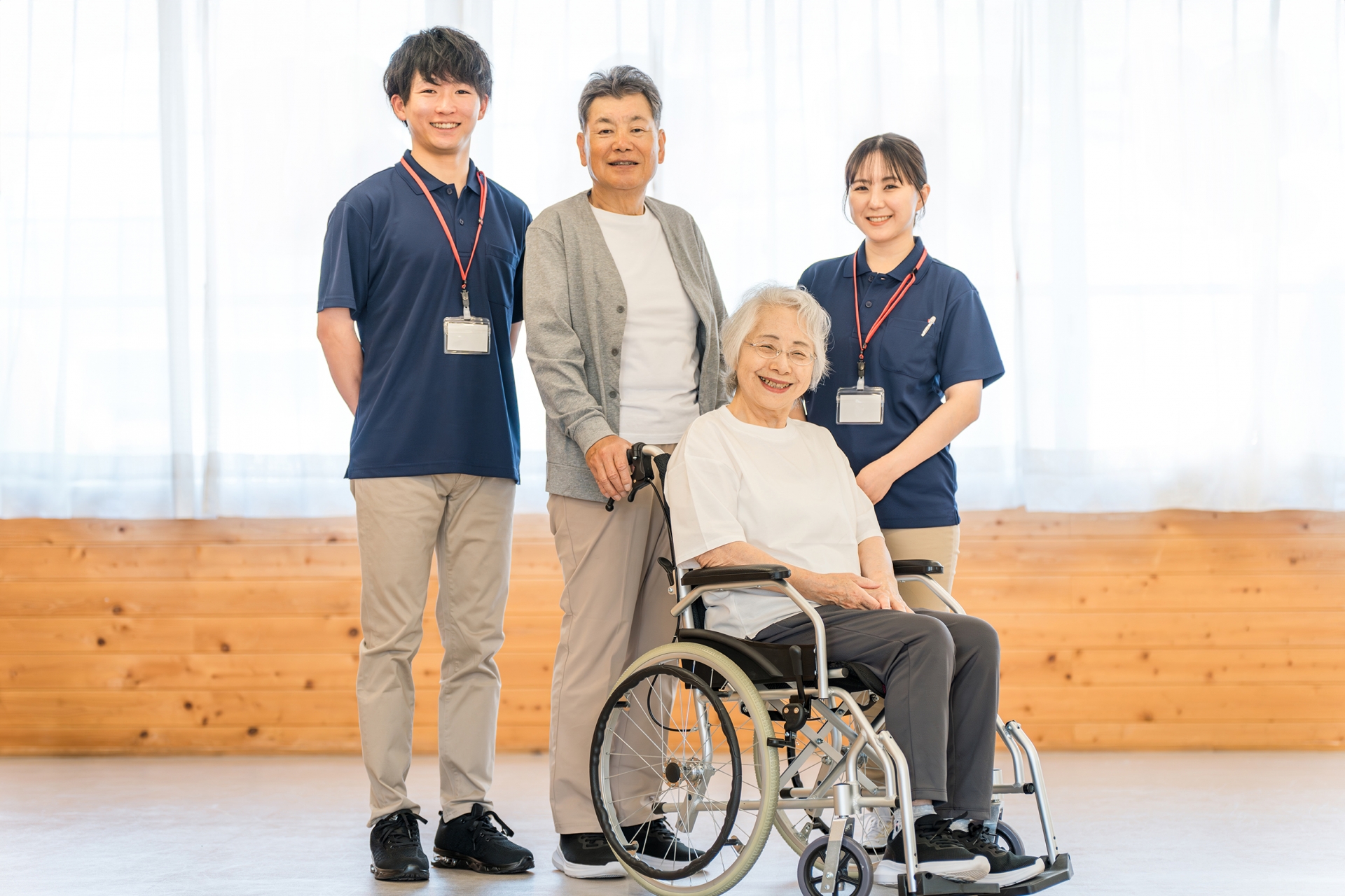 老人ホームにいるシニア夫婦と介護職員