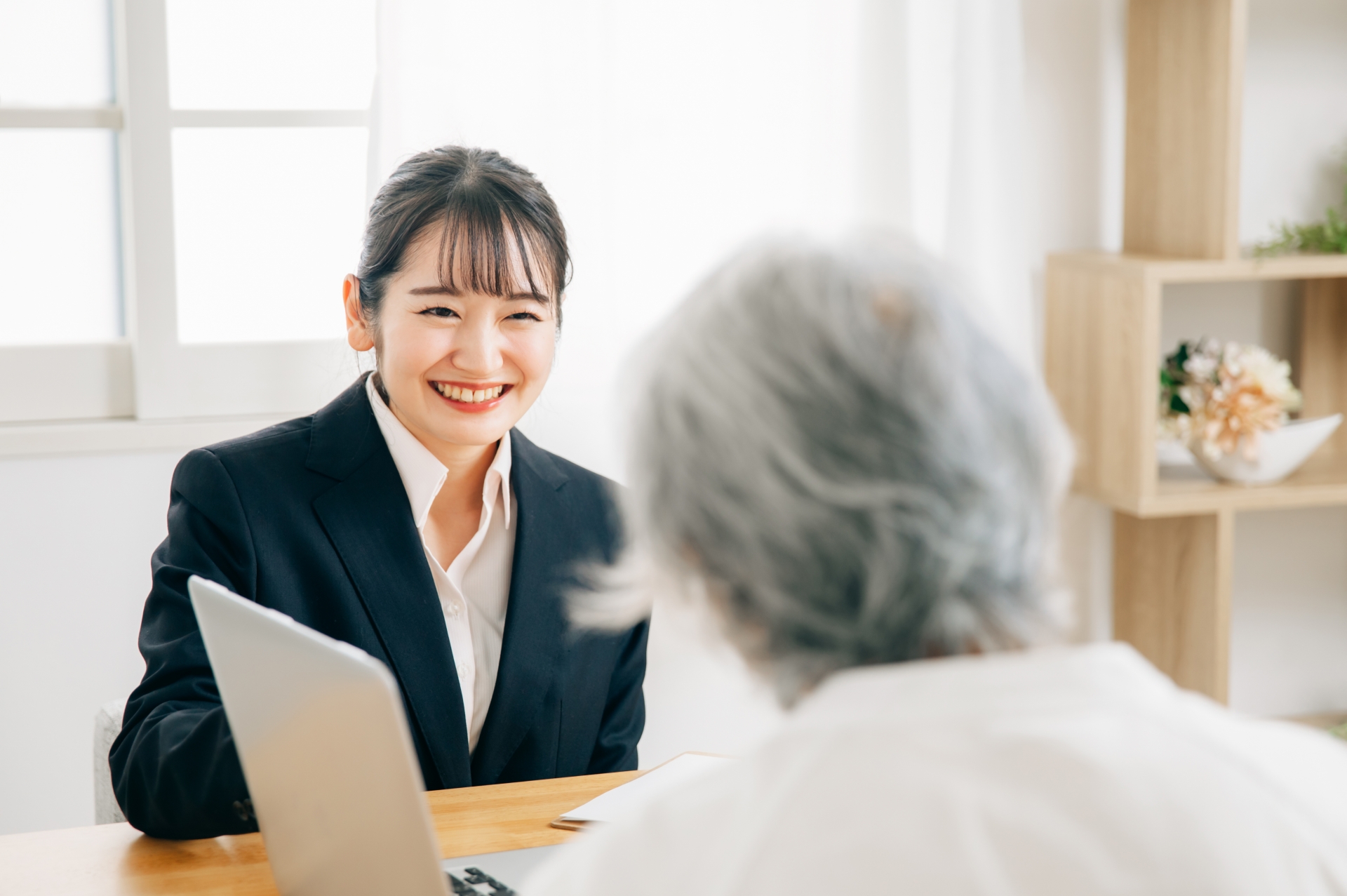 打ち合わせするスーツ姿の女性と高齢者女性