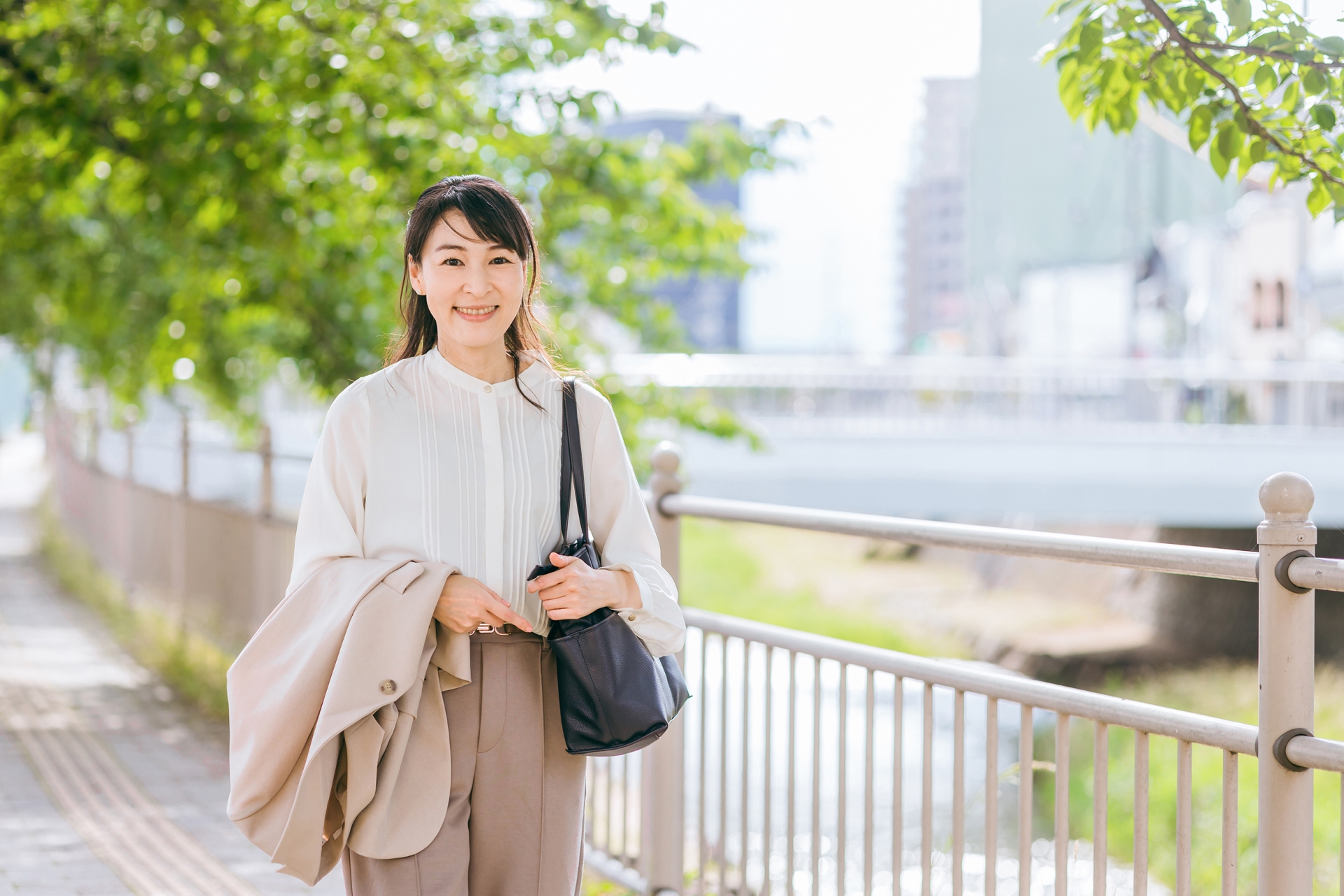 川沿いを歩いて通勤するビジネスウーマン