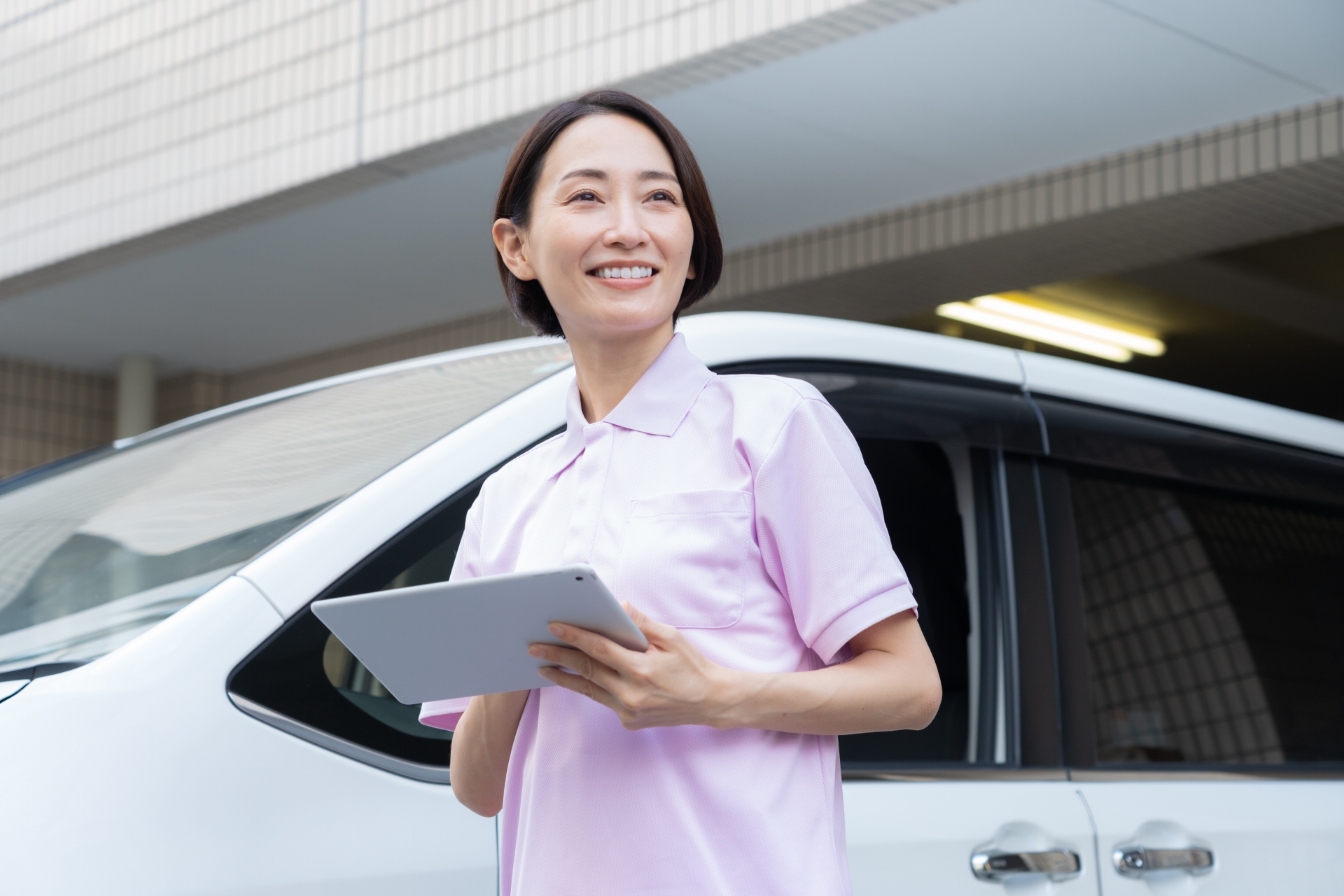 車で訪問介護をするミドルの女性介護士