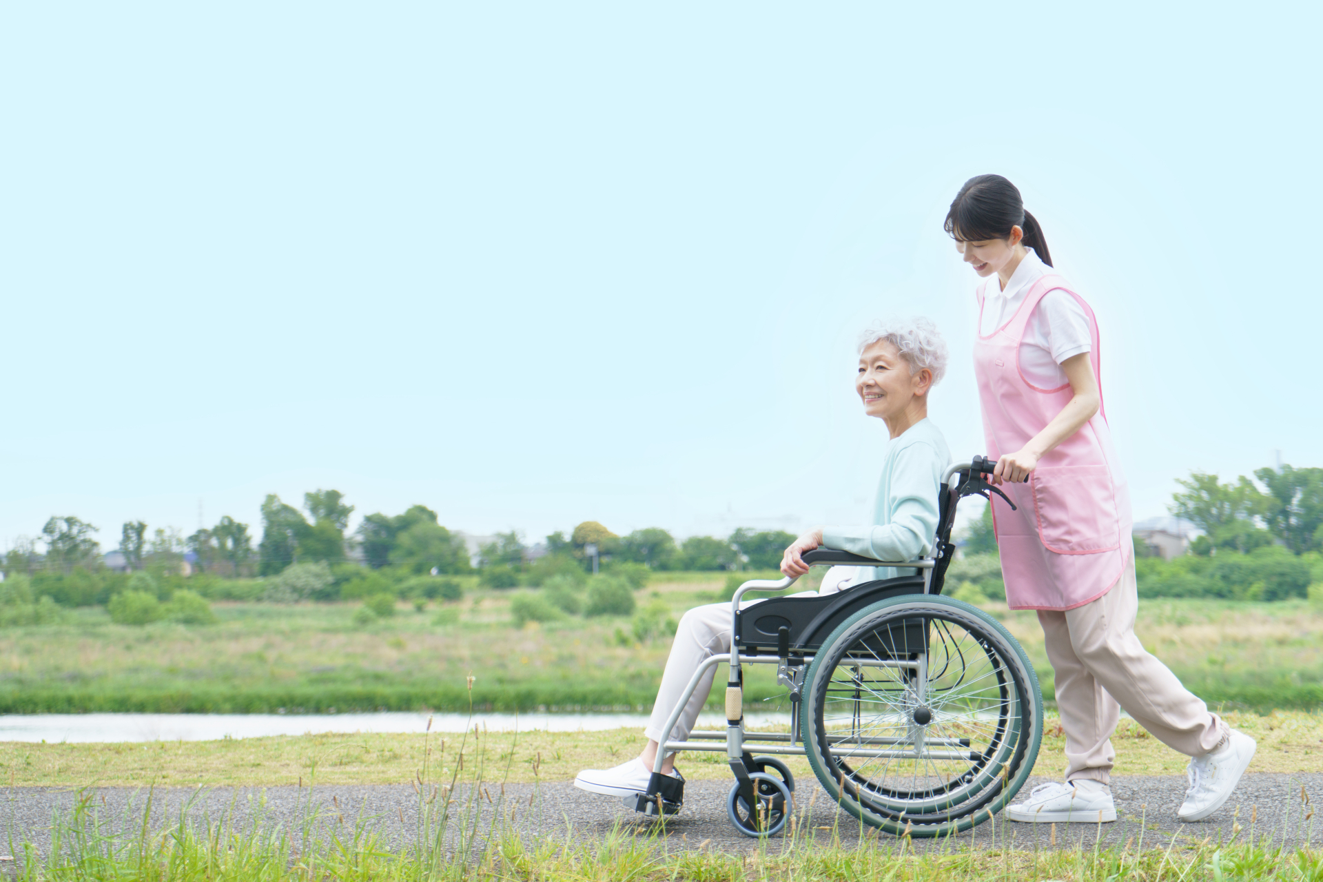 車椅子のシニア女性と介護士の女性