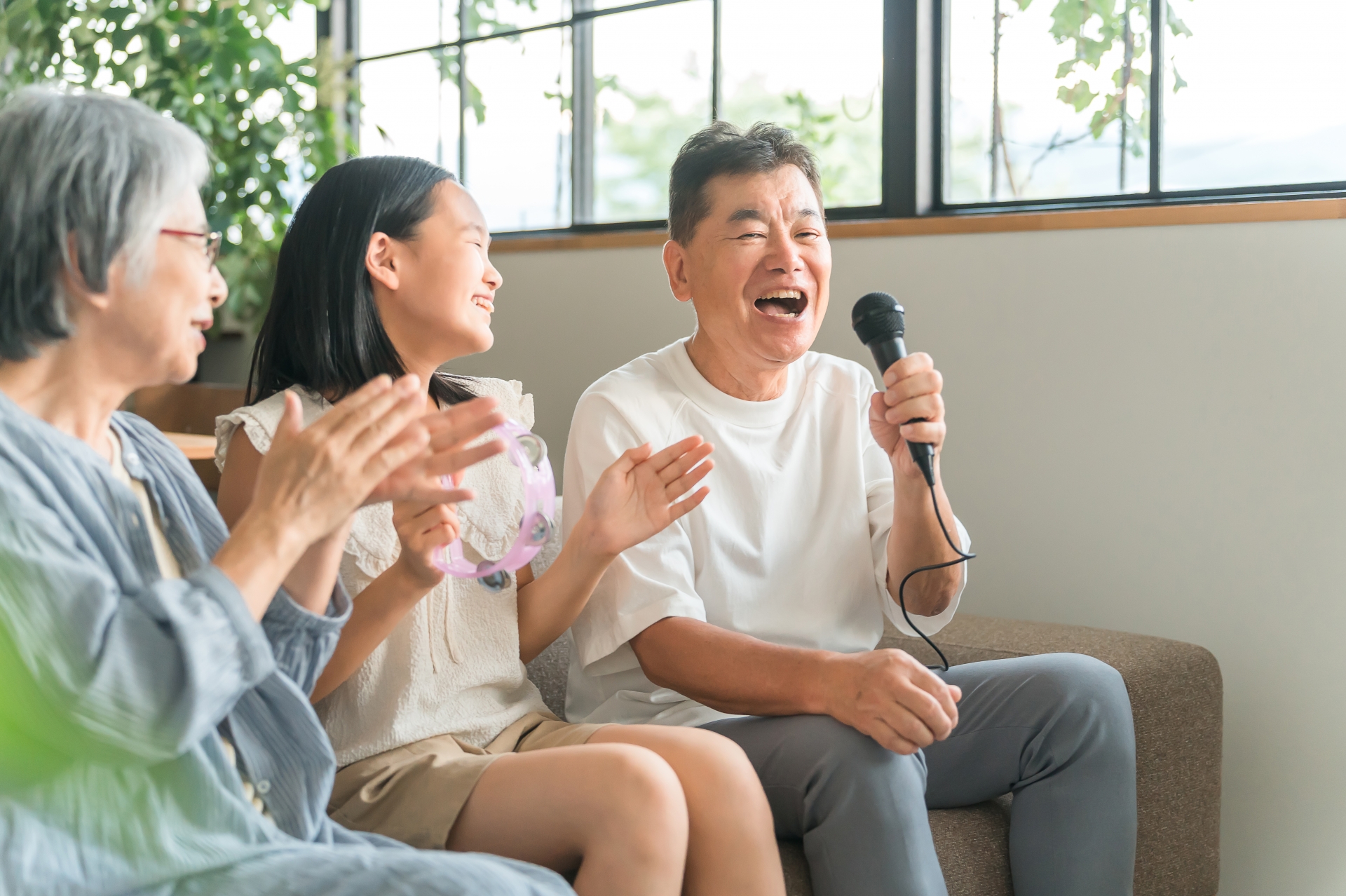 家でカラオケを楽しむ祖父母と孫・女の子