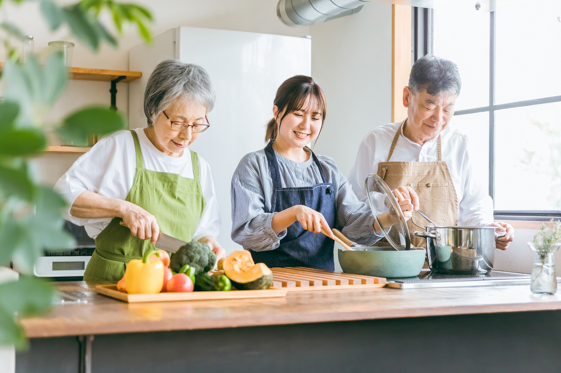 料理する高齢者夫婦と若い女性（料理教室）