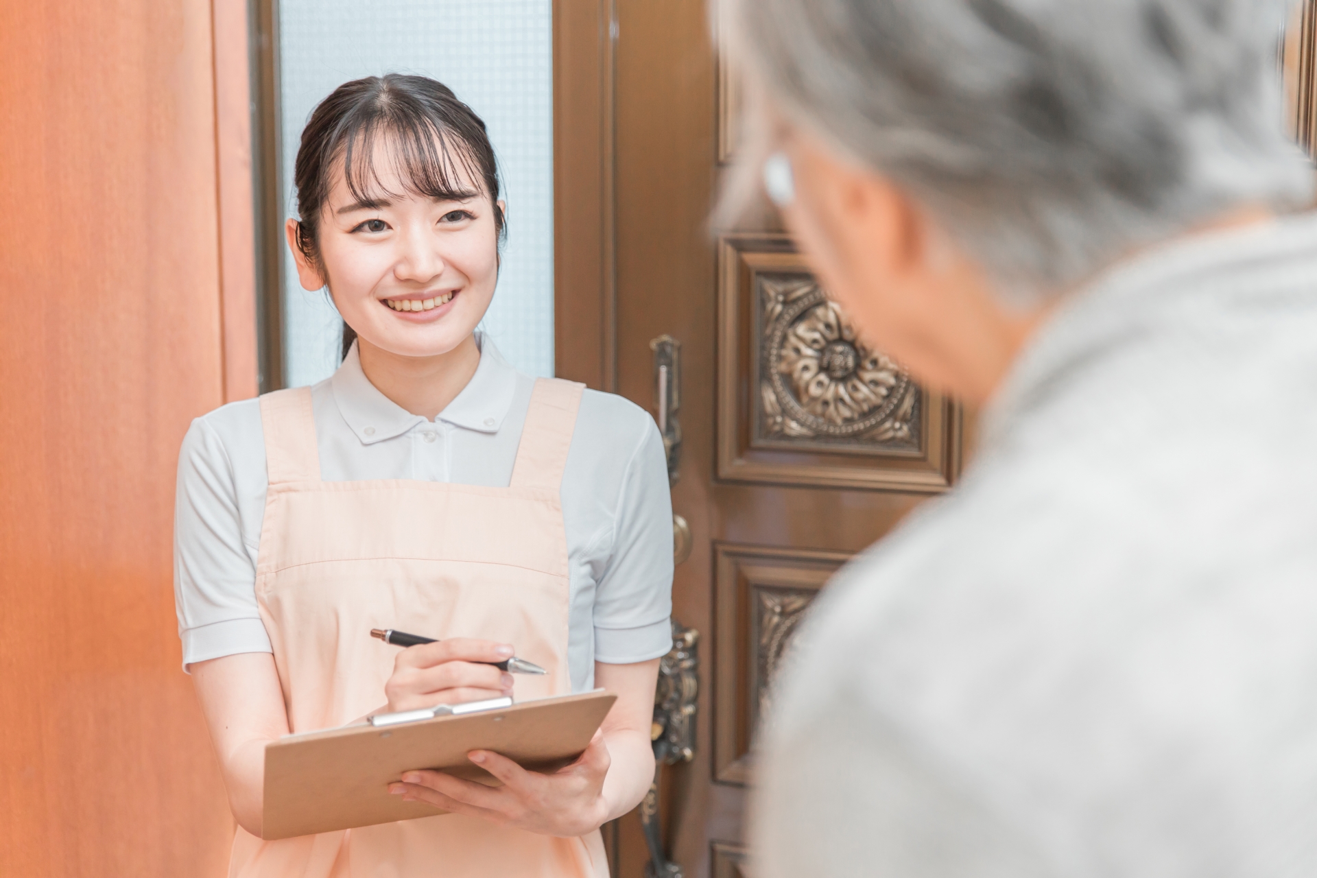 高齢者住宅に訪問する女性(書類)