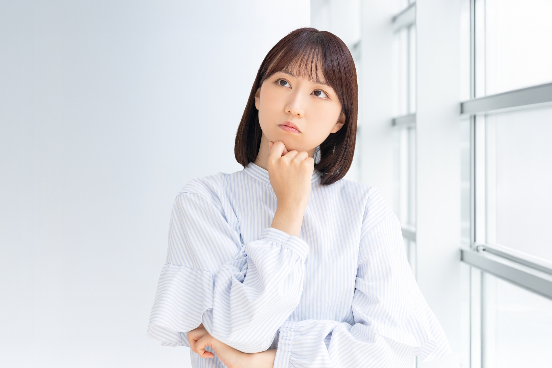 考えごとをする若い女性・ビジネスウーマン