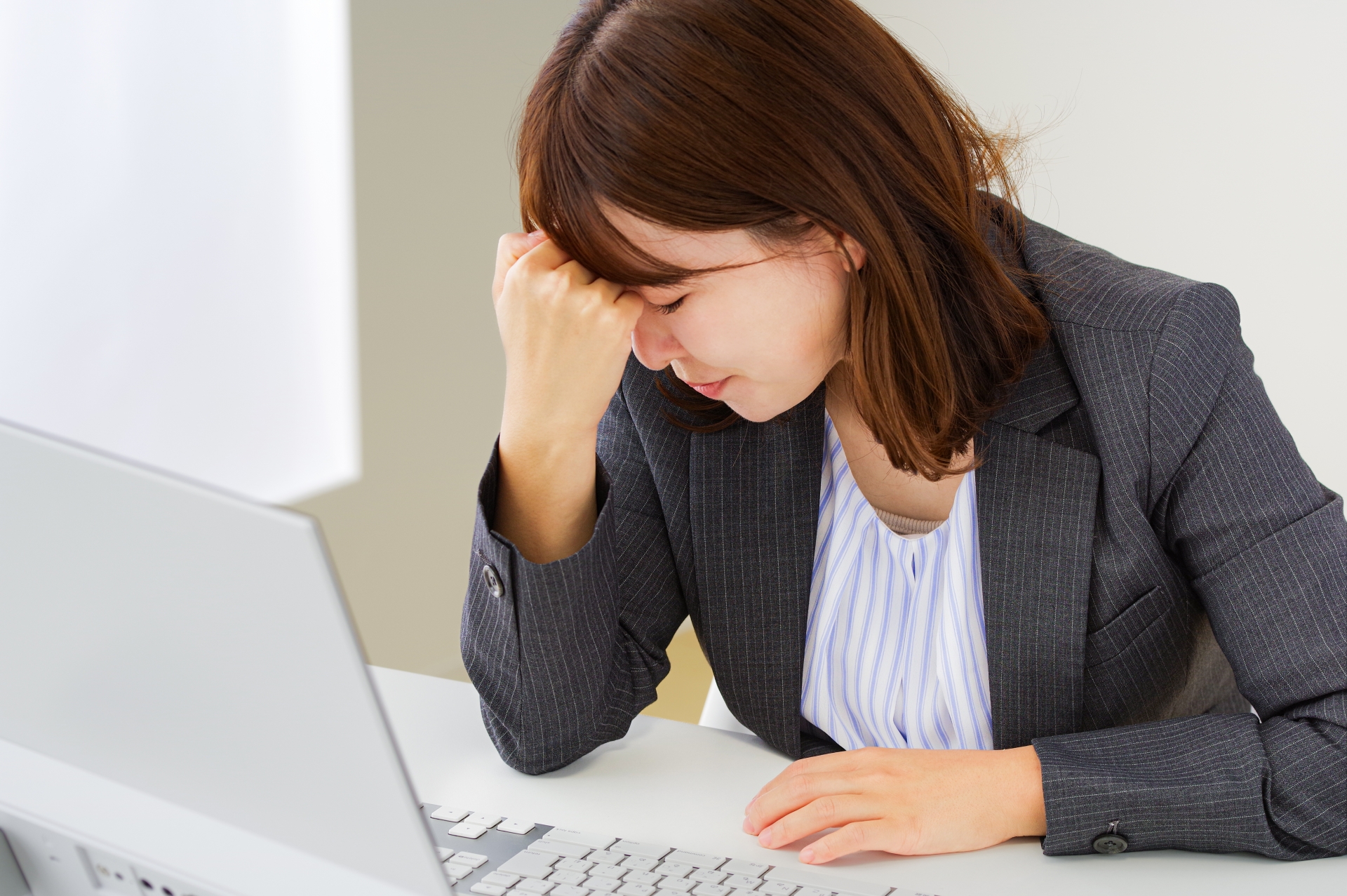 疲労が溜まってつらそうな女性社員