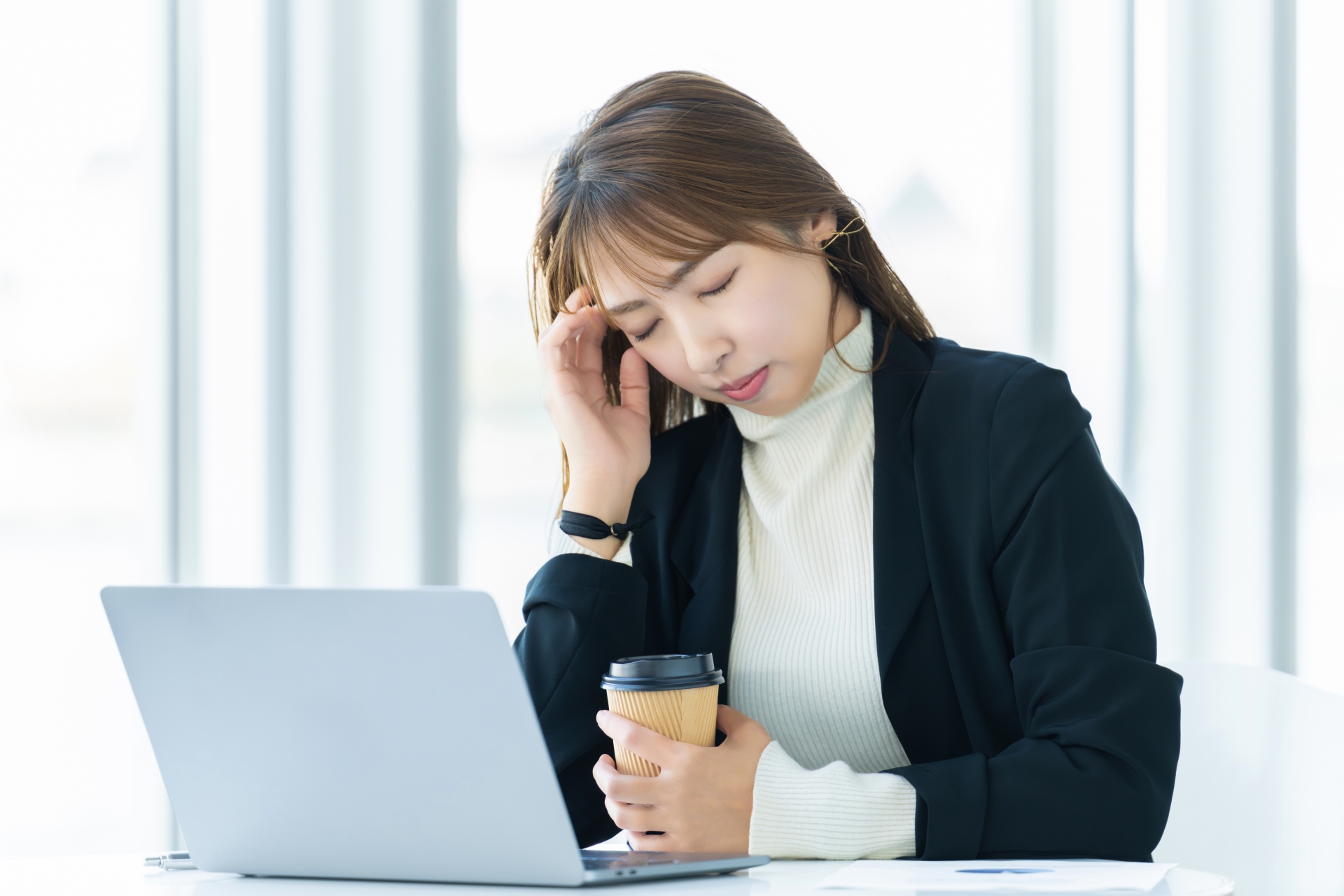 パソコンを使いながら悩む女性