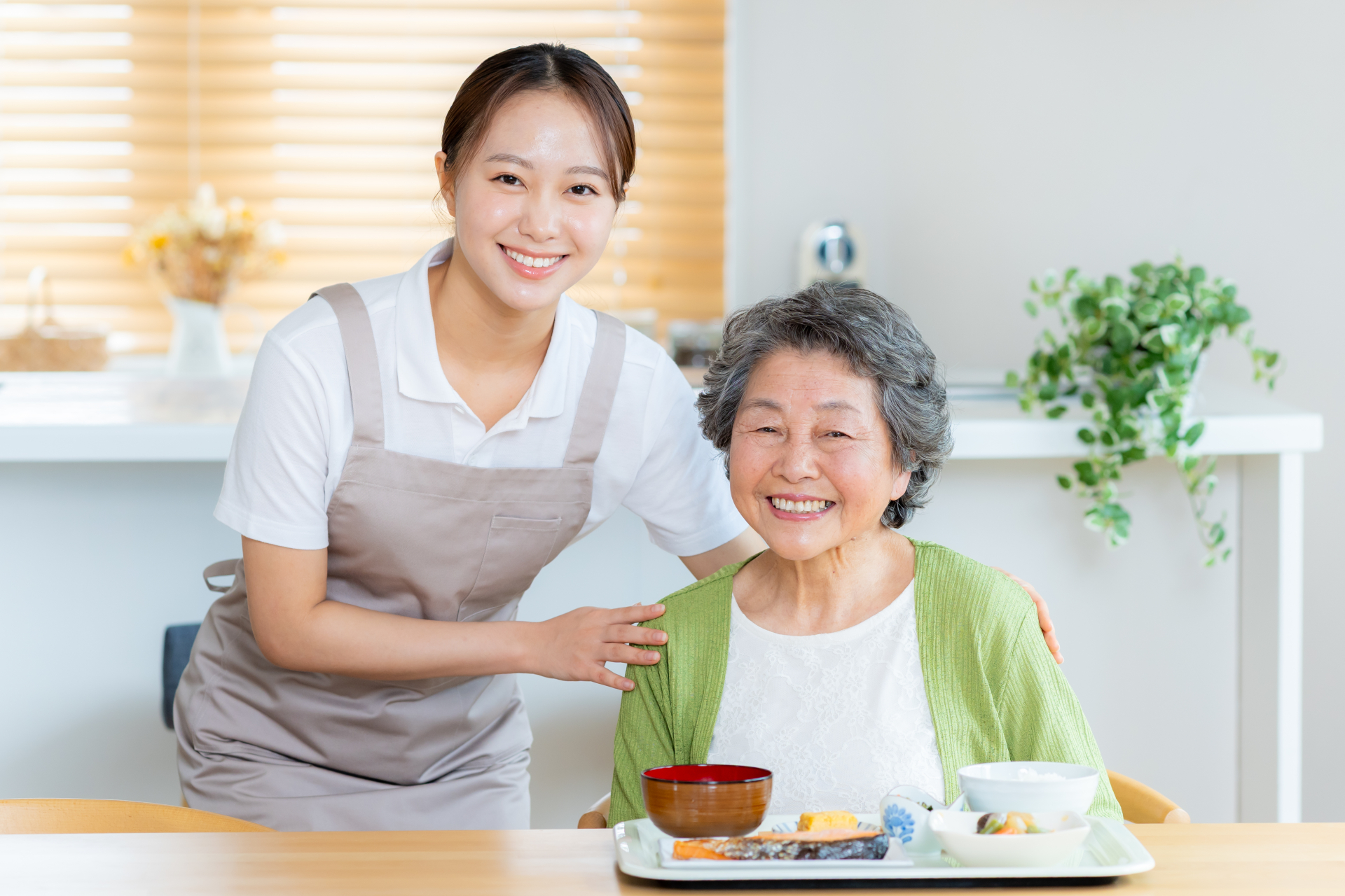 食事の準備をするヘルパーとシニア女性