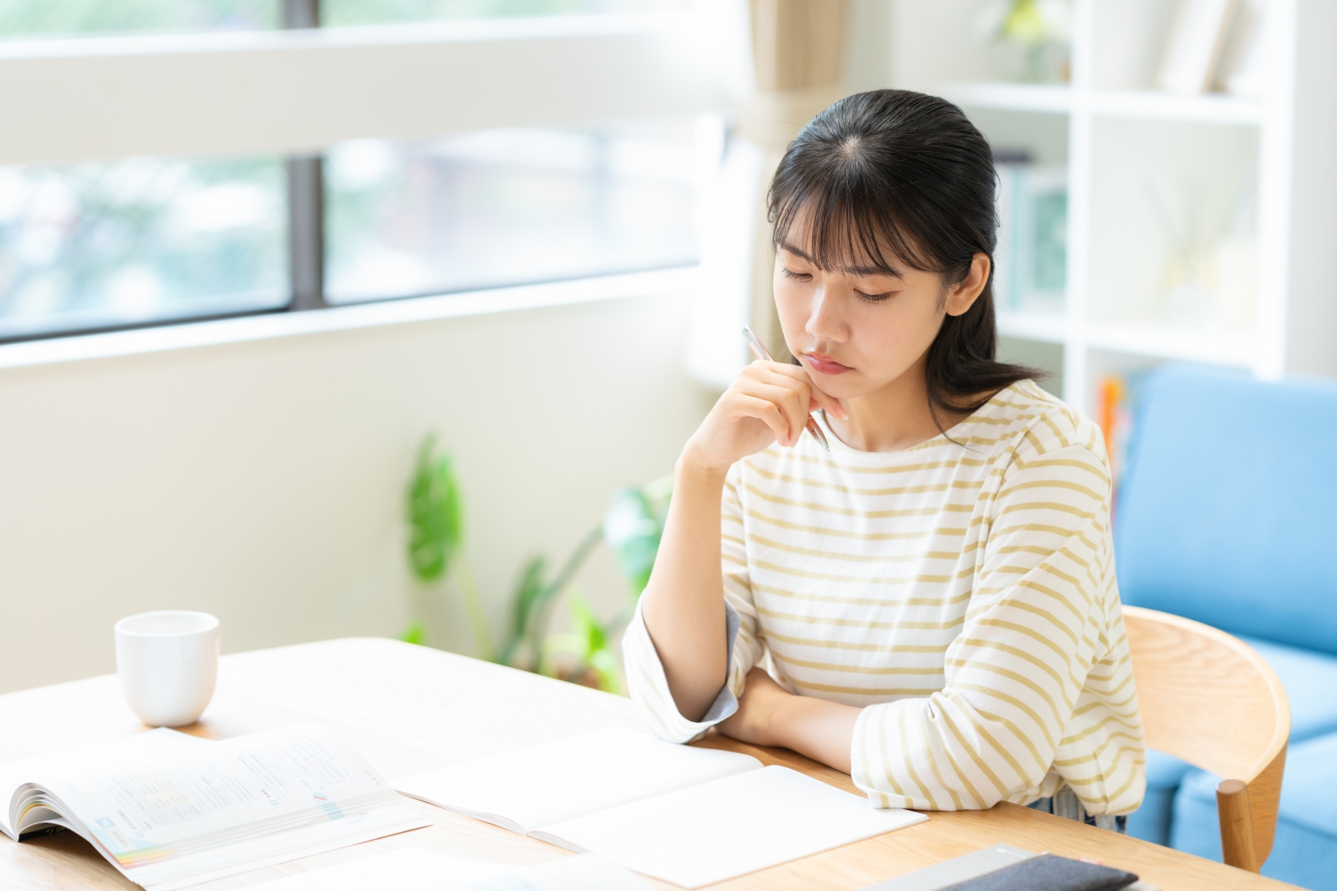 リビングで勉強をする大学生の女性