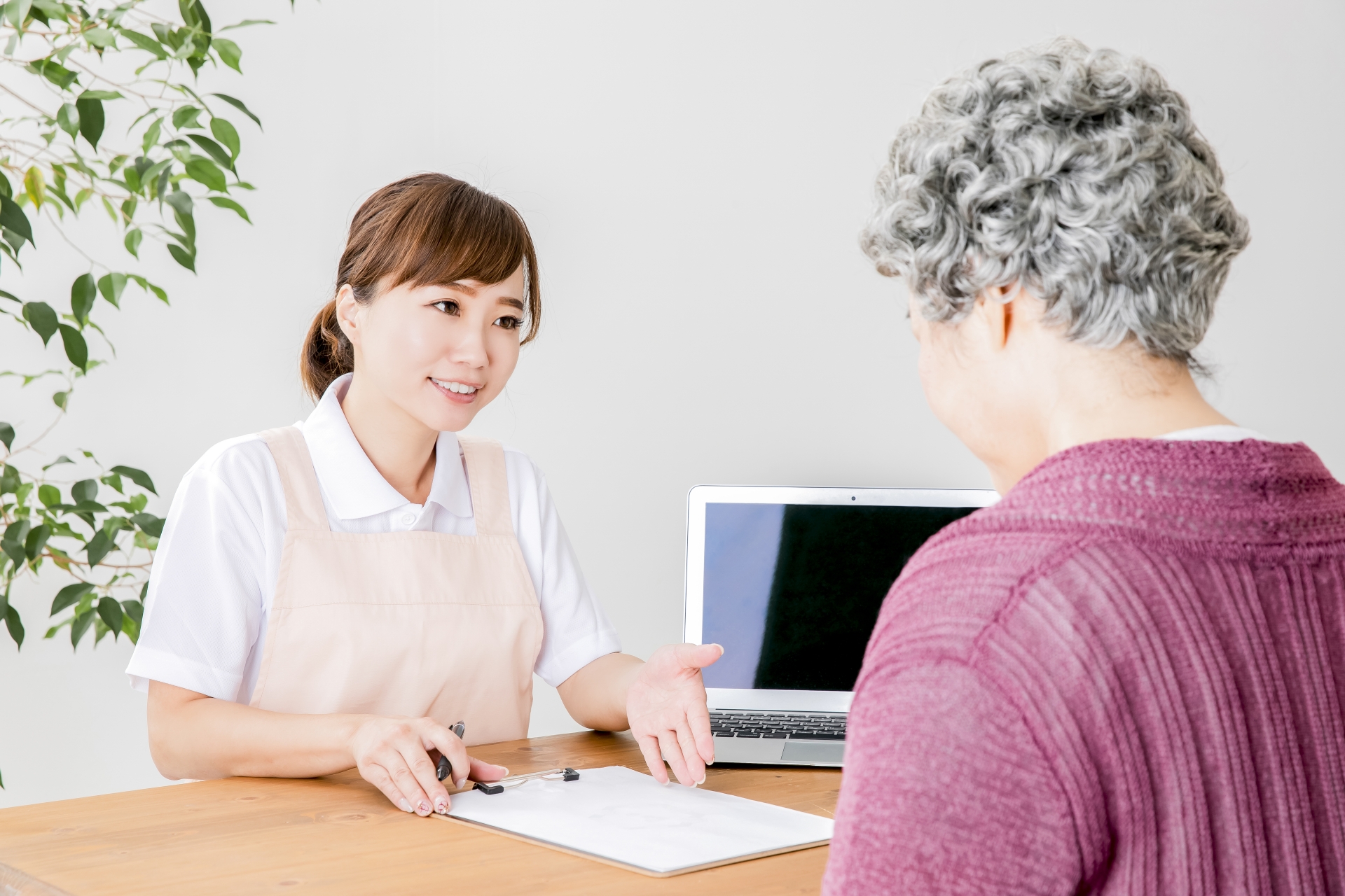 説明する介護士と高齢者の女性